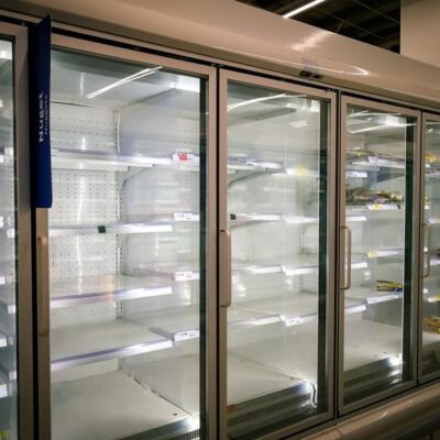 Puste półki w sklepie z systemami chłodniczymi.