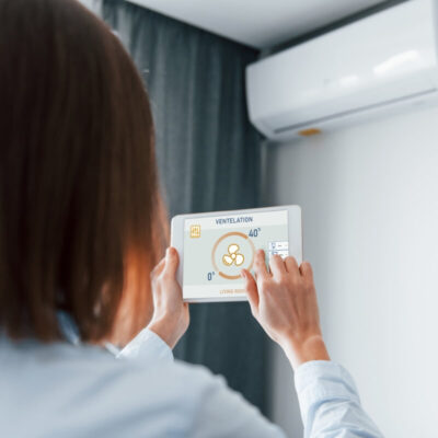 Osoba obsługuje klimatyzację do mieszkania za pomocą tabletu.