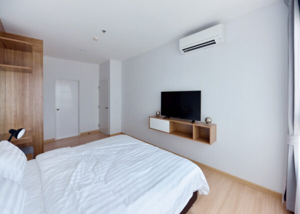 Sypialnia z nowoczesnym wystrojem i klimatyzacją do domu nad telewizorem.