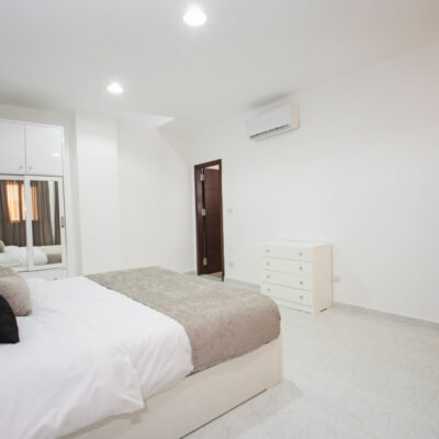 Pokój z łóżkiem i szafą ma zainstalowaną klimatyzację na ścianie.