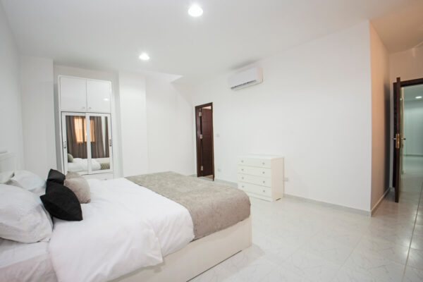 Pokój z łóżkiem i szafą ma zainstalowaną klimatyzację na ścianie.